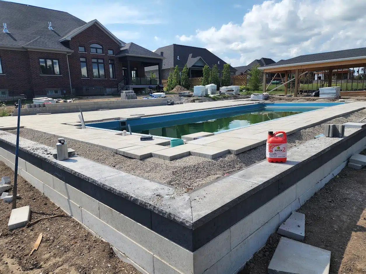 backyard under construction with pool and interlocking bricks